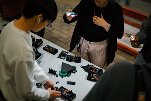 An individual is working on assembling robot  components at a table.