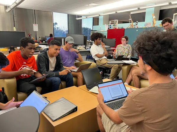 The University Rover Challenge team engages in a discussion whilst working on laptops and tablets at the Makerspace.